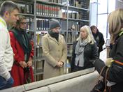 Adelheid Schmitz mit den Gästen vor den Steintrögen in der Bibliothek der HSD